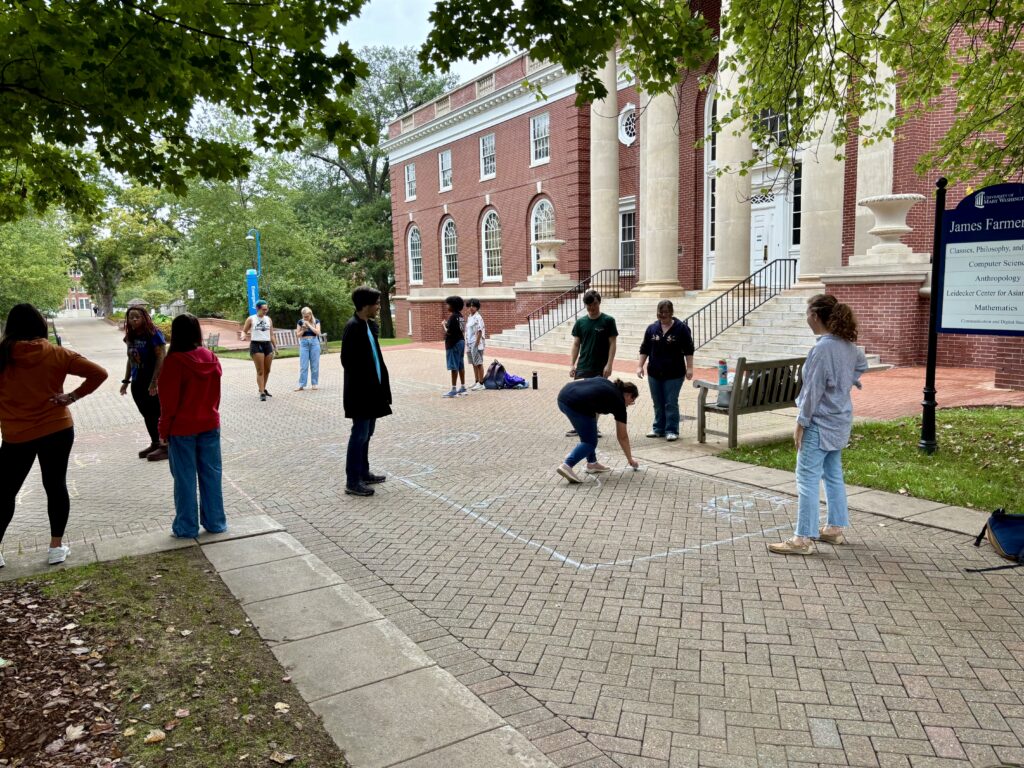 students conducting a class activity outside on a college campus